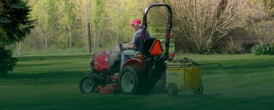 man using a sprayer on his lawn